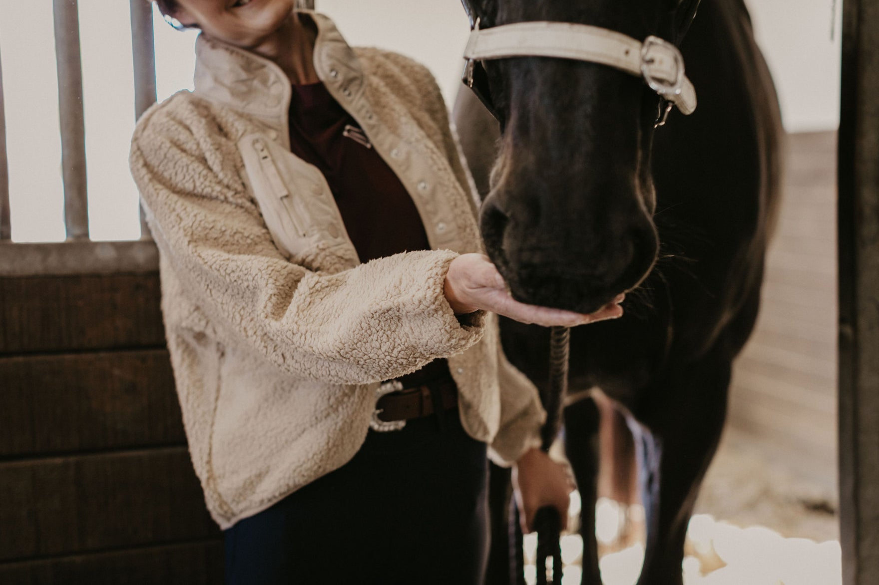 Picture an assortment of versatile equestrian outerwear suitable for any kind of weather conditions. Display a Middle-Eastern female rider with a light-weight, water-resistant jacket for sudden shower