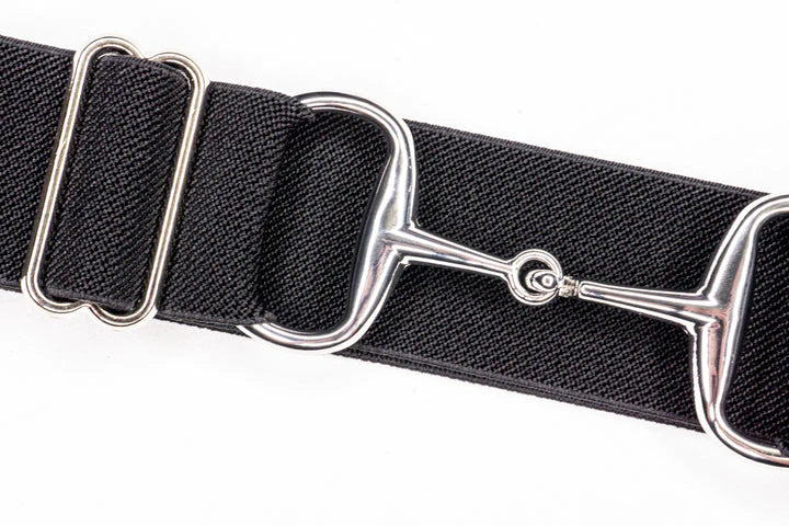 A meticulously crafted belt showcasing a distinct equestrian flair. The focal point of the accessory is a polished metal horse bit, serving as a buckle. The leather strap, rich in natural honey tones,